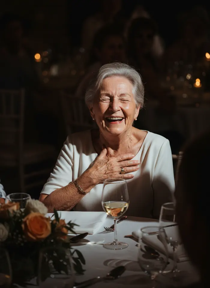 Babcia śmiejąca się przy stole weselnym